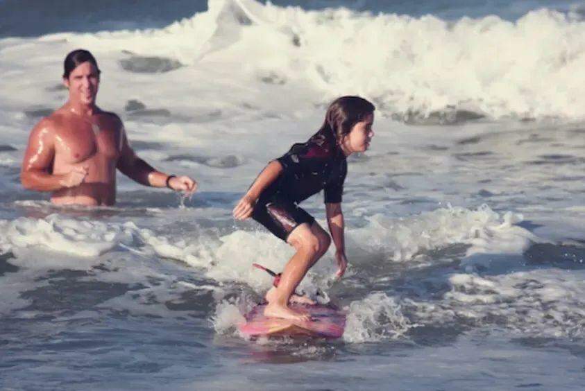 Caroline se arrisca em suas primeiras ondas junto ao pai e incentivador Darren Marks