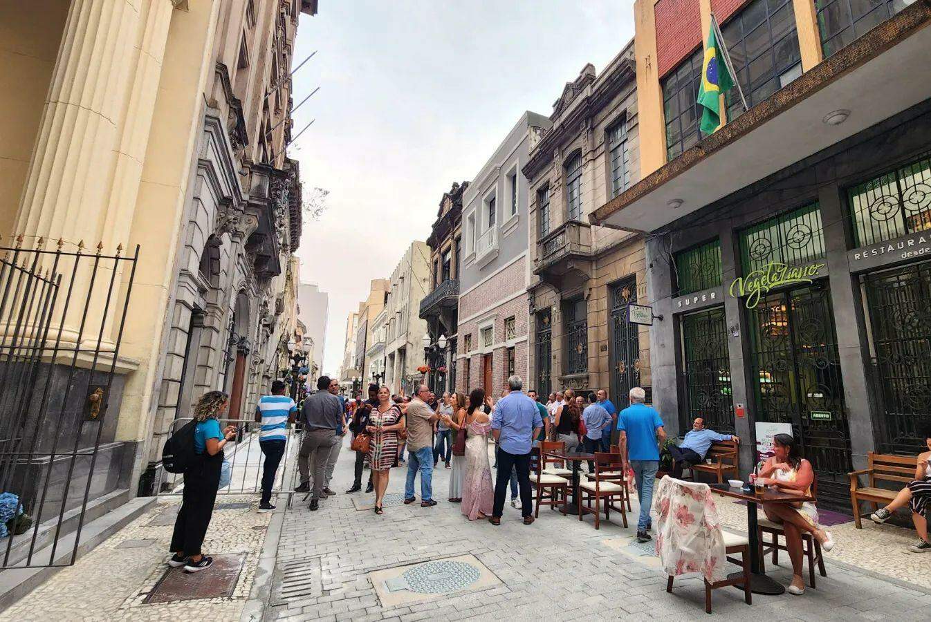 Mesas externas são posicionadas em frente aos estabelecimentos para atender clientes na Rua XV de Novembro, em Santos