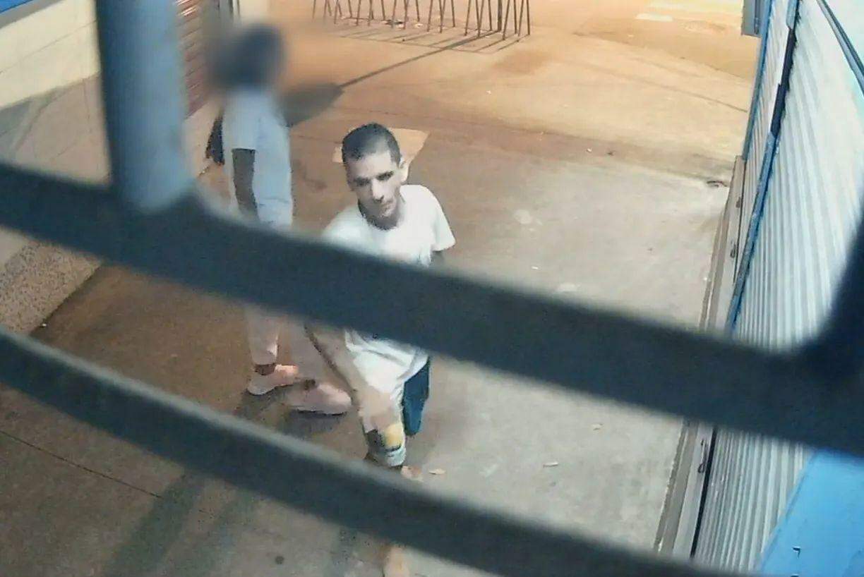 Imagens de câmera de segurança mostram suspeito com uma bebida na mão acompanhado de jovem