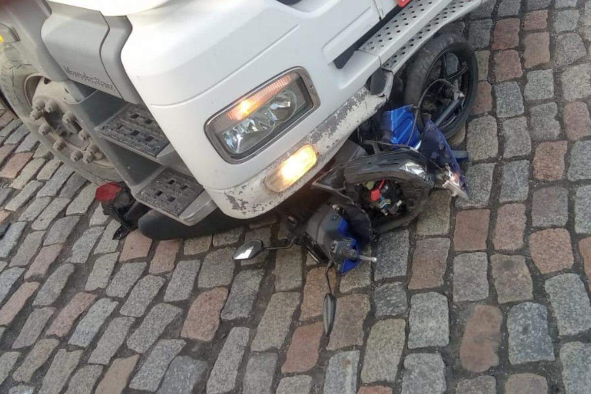 A moto ficou presa debaixo do caminhão (Reprodução)
