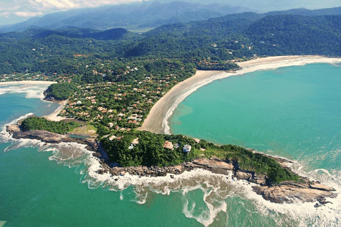 Visitantes podem aproveitar banho de mar e cachoeira que deságua no oceano na praia restrita de Guarujá