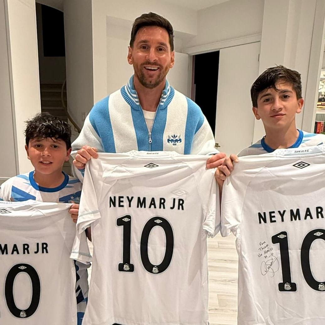 Messi e os filhos com a camisa autografada enviada pelo amigo e ex-parceiro de clube, Neymar