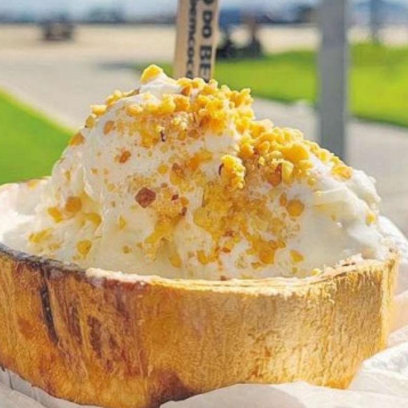 Servido na casca do coco, ele vem com complementos como paçoca