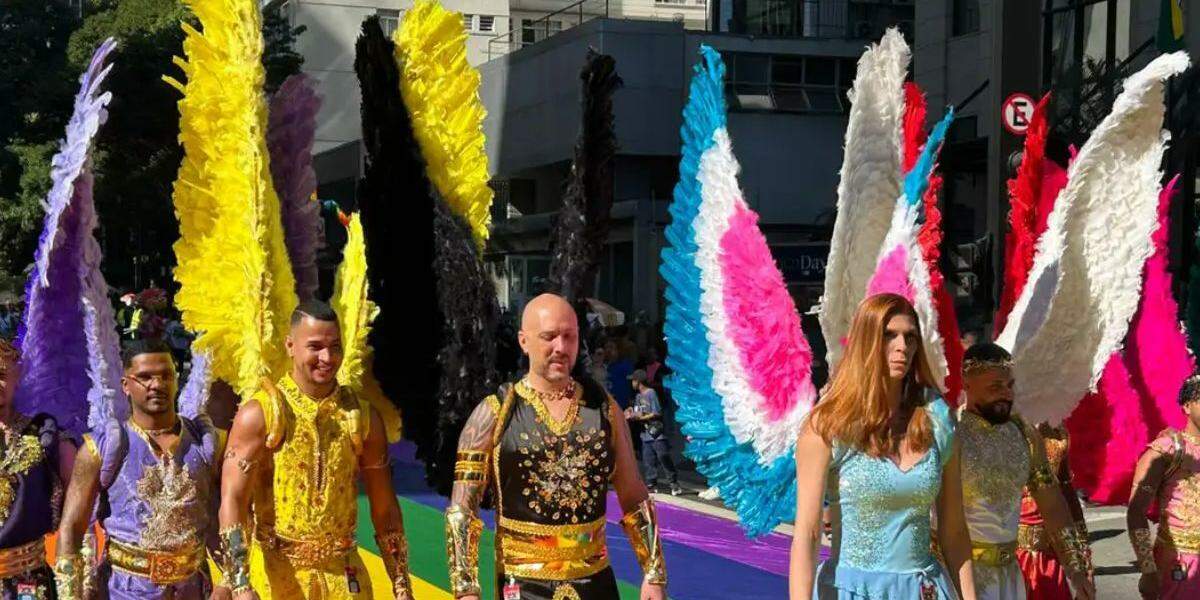 Parada LGBT+ entre o colorido de leques e o amarelo da Seleção