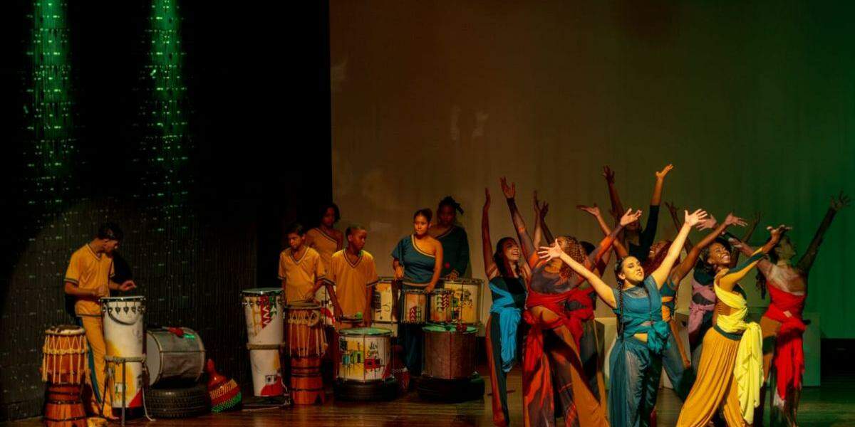 Jovens bailarinos da Cia Jovem de Dança do Instituto Arte em Movimento e percussionistas do Coletivo Querô, do Instituto Arte no Dique, se apresentam no espetáculo "Brasil, Mostra a tua Cara: Brasilidades em Movimento", que terá duas apresentações gratuitas em Santos neste sábado (25)