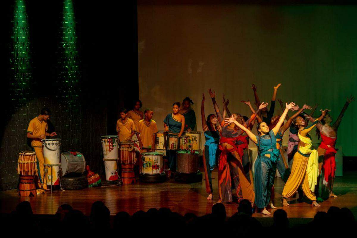 Jovens bailarinos da Cia Jovem de Dança do Instituto Arte em Movimento e percussionistas do Coletivo Querô, do Instituto Arte no Dique, se apresentam no espetáculo "Brasil, Mostra a tua Cara: Brasilidades em Movimento", que terá duas apresentações gratuitas em Santos neste sábado (25)