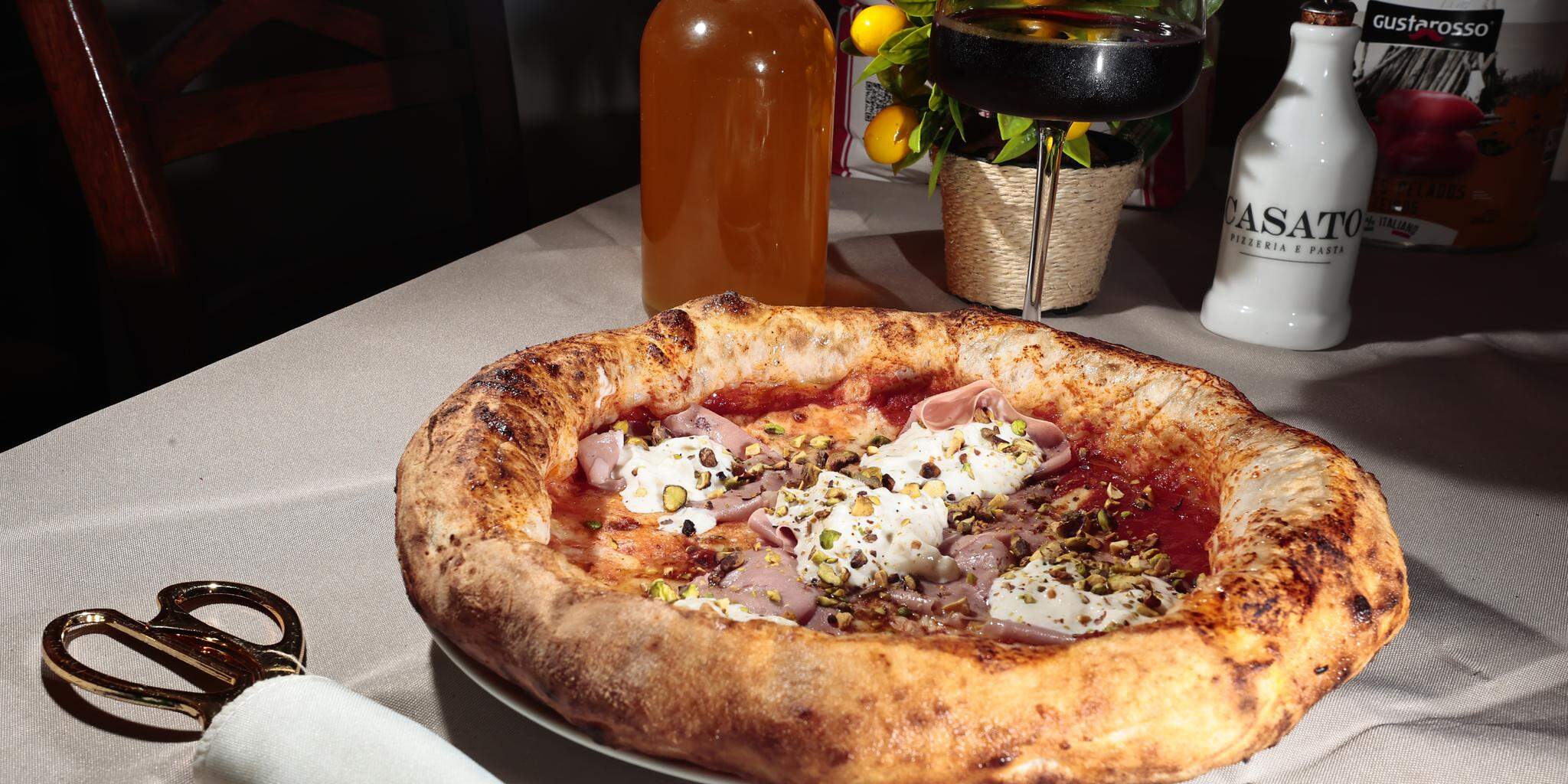 Assim como é comum na Itália, a pizza é cortada com tesoura