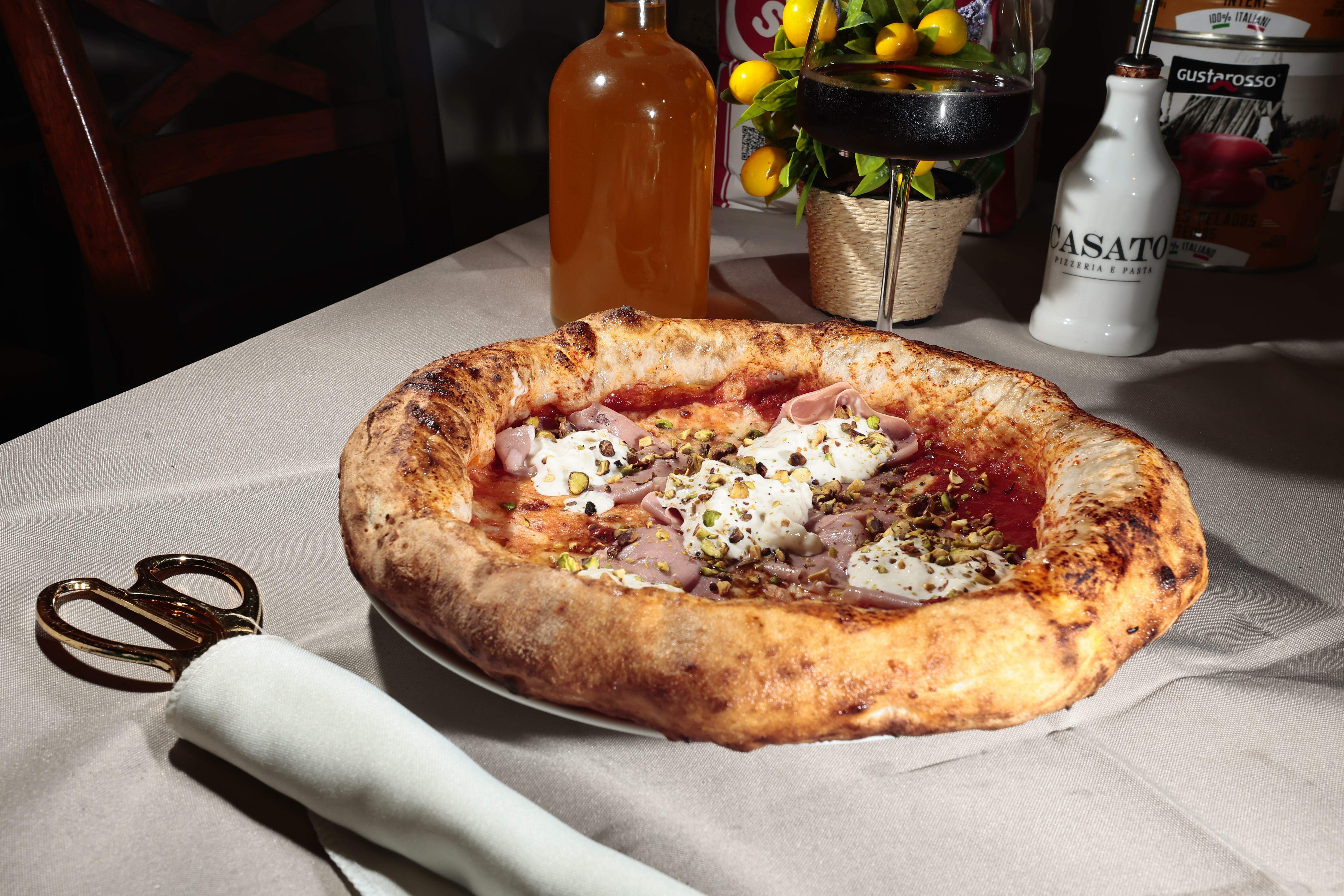 Assim como é comum na Itália, a pizza é cortada com tesoura