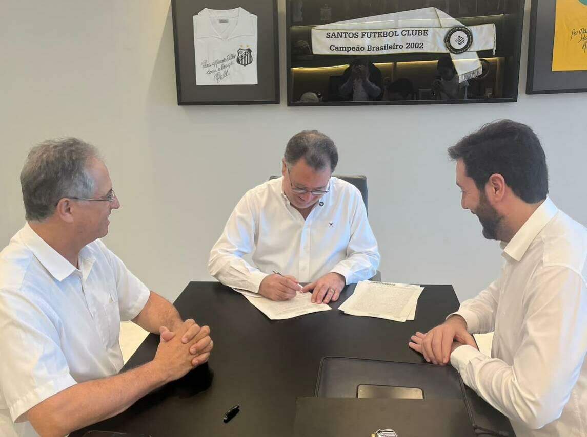O presidente Marcelo Teixeira assina o acordo, ao lado do representante da Saint-Gobain (à direita)