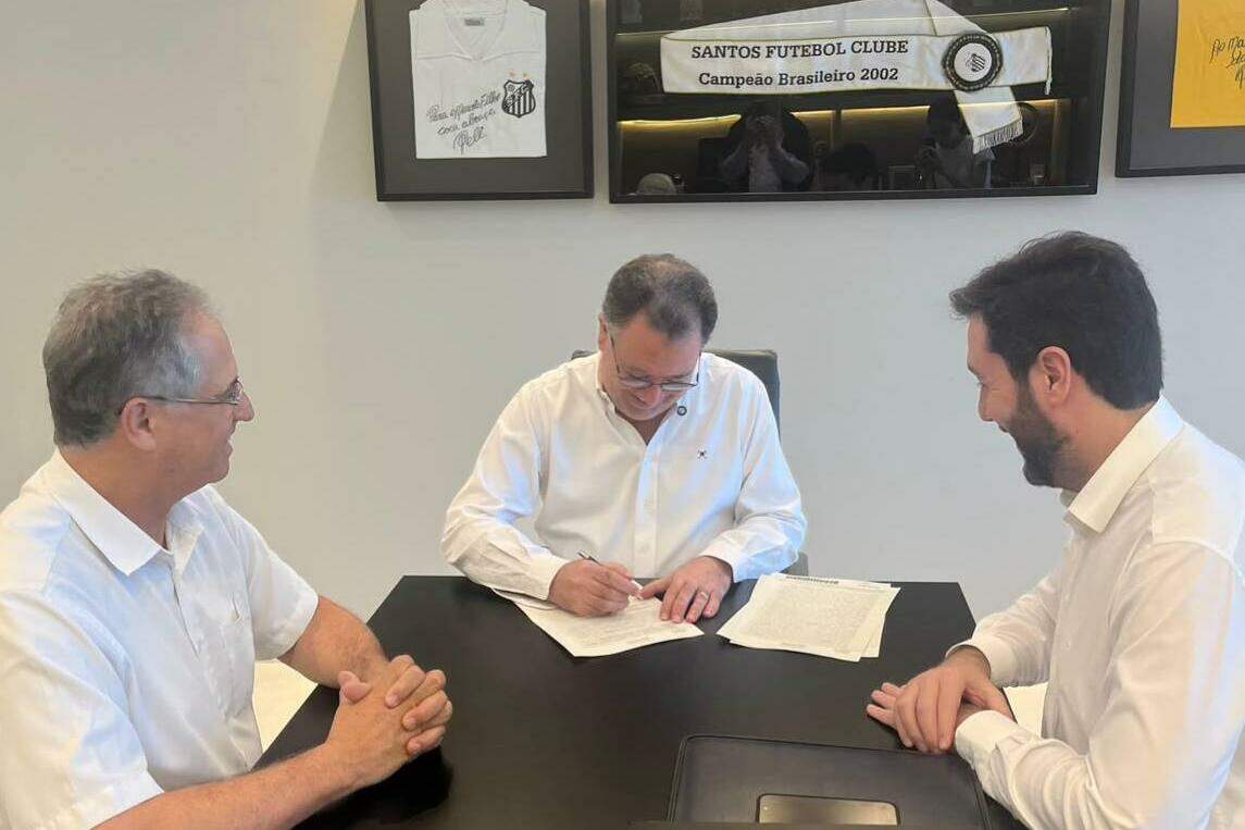 O presidente Marcelo Teixeira assina o acordo, ao lado do representante da Saint-Gobain (à direita)