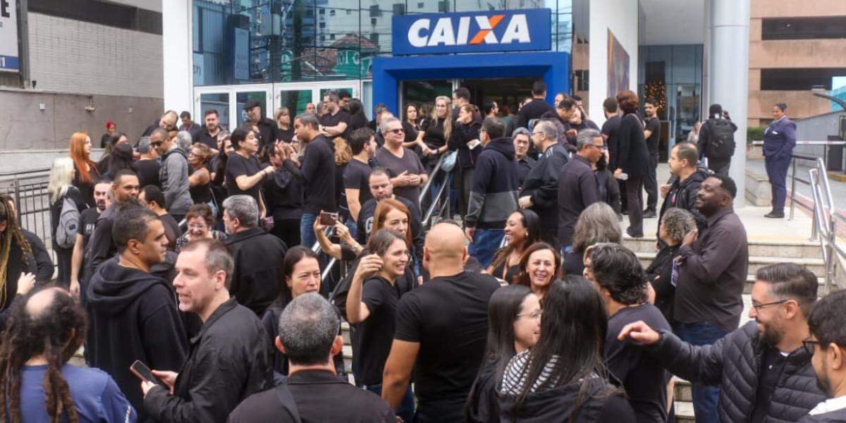 Os trabalhadores realizaram um ato público em frente à agência da Caixa no Gonzaga, em Santos, na manhã desta terça-feira
