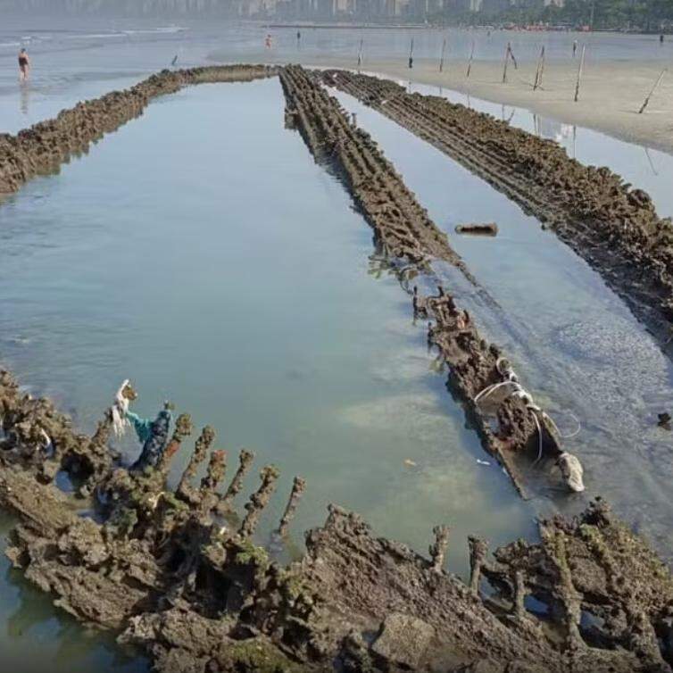 Recuo do mar em Santos deixa à mostra destroços de veleiro inglês na praia, próximo ao Canal 5
