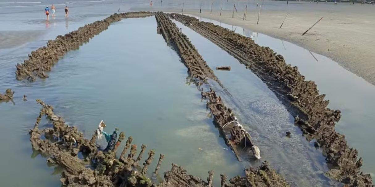 Recuo do mar em Santos deixa à mostra destroços de veleiro inglês na praia, próximo ao Canal 5