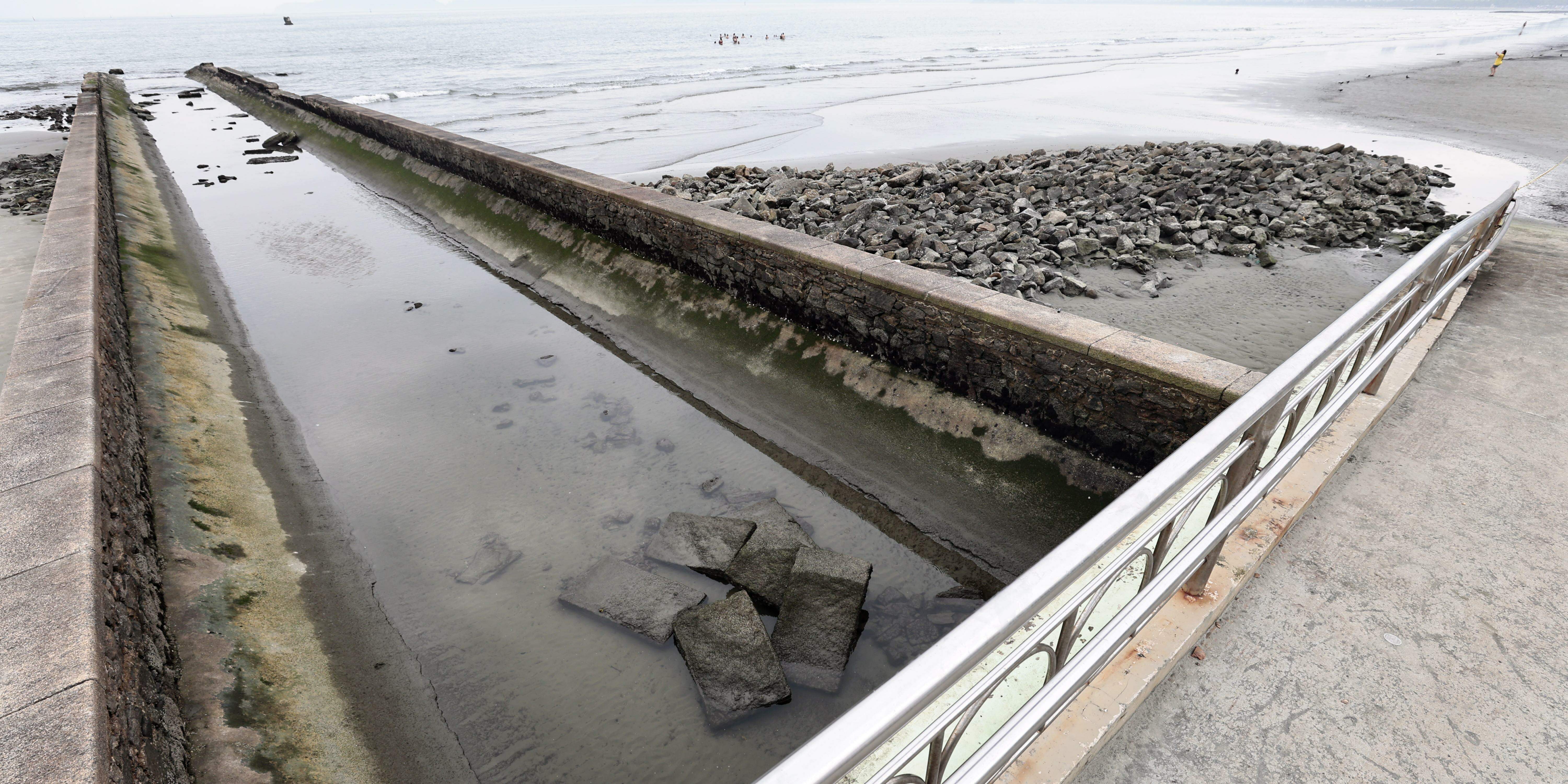 As pedras na faixa de areia, no pontilhão do Canal 6, serão utilizadas nas obras, quando retomadas