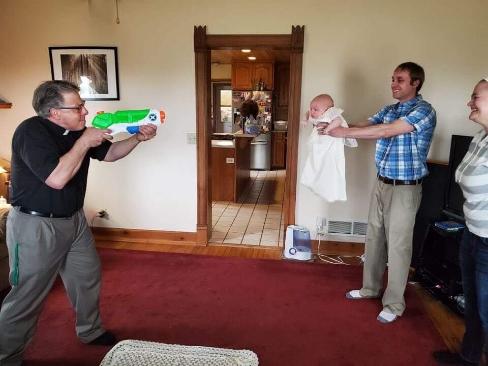 Padre utiliza arma de água para batizar bebê
