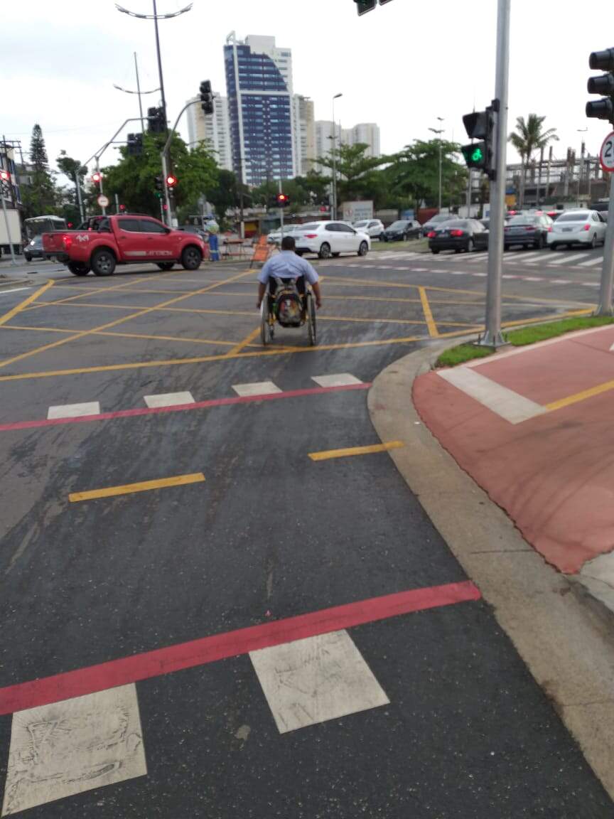 Cadeirante tendo que atravessar fora da faixa, por conta das bicicletas