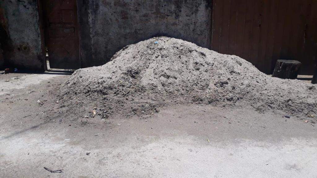 Areia fica acumulada pelas ruas do morro e moradores tenta limpar como podem