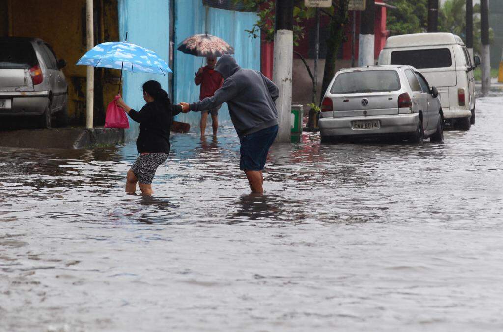 Pedestres atravessam Av. Nossa Senhora de Fátima, alagada pela chuva 