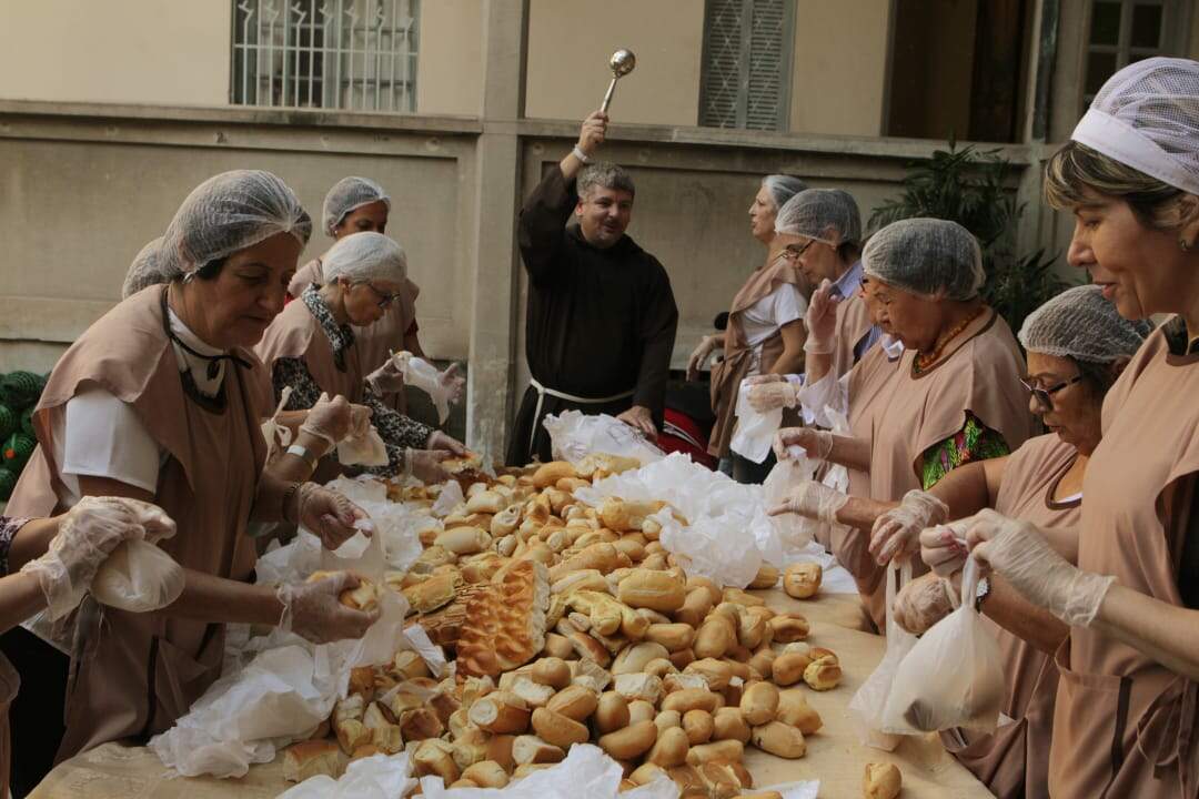 Tradicionais pães são benzidos antes da distribuição nas barracas; dia teve muitas histórias de fé