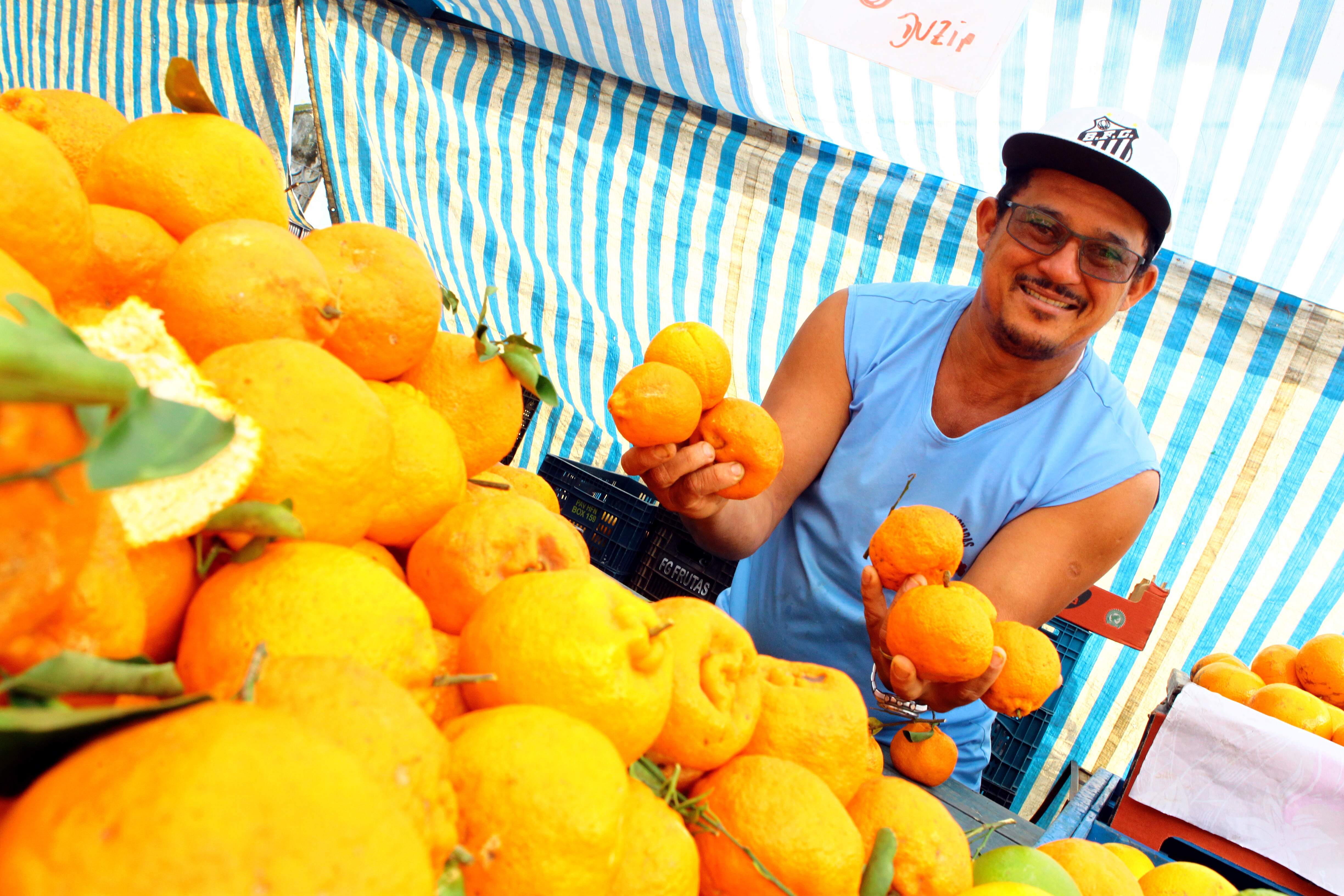 O feirante Márcio de Oliveira Rocha não economiza sorrisos para atrair a freguesia 