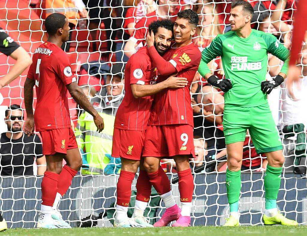 Roberto Firmino abraça Salah após um dos gols na vitória do Liverpool