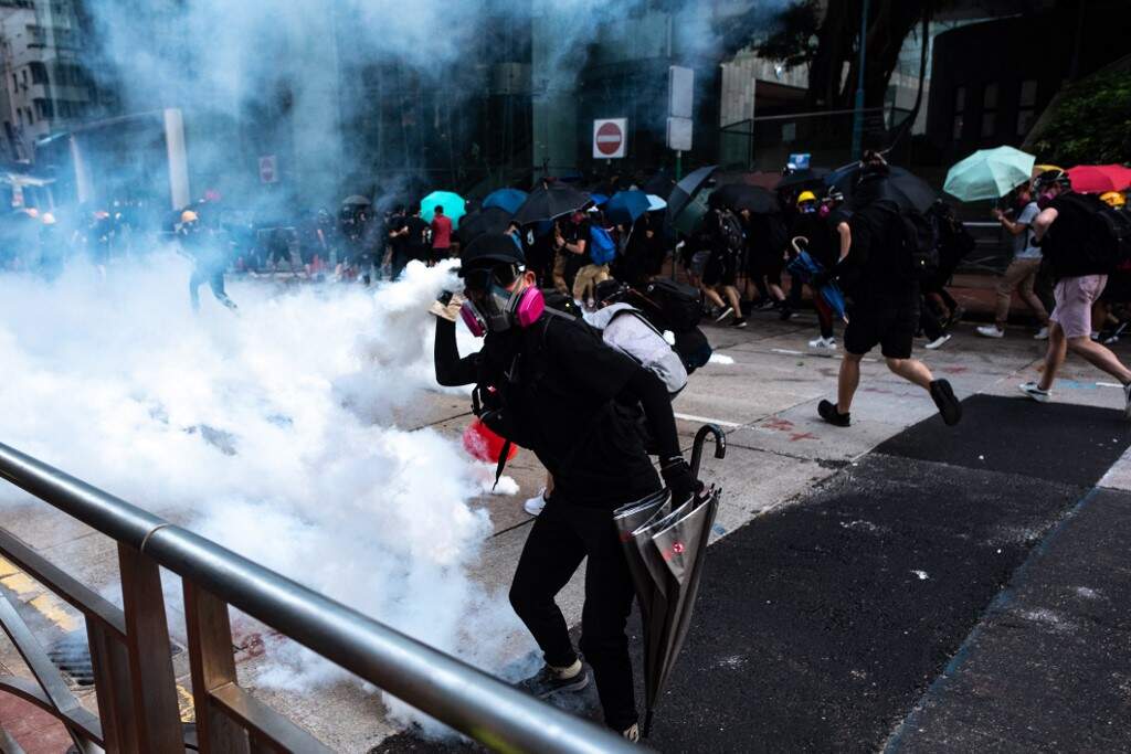 Manifestantes pró-democracia reagem após polícia atirar gás lacrimogênio em Hong Kong