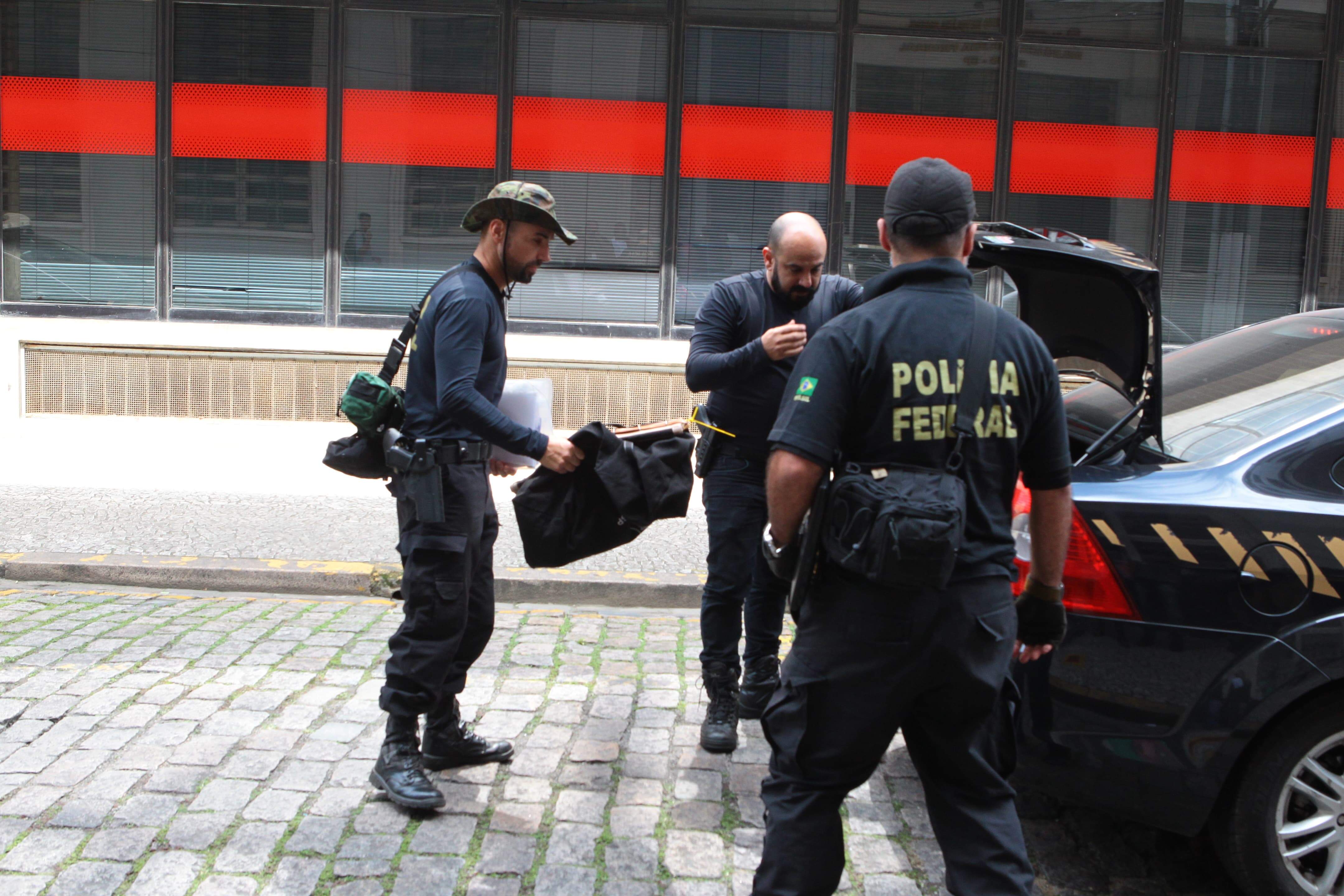 Movimento na porta da Polícia Federal em Santos. Chegada de detido e materiais apreendidos 