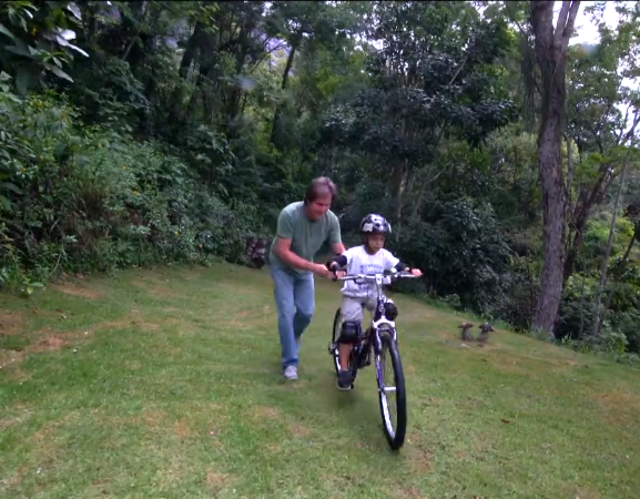 Felipe brinca com a bicicleta de uma das irmãs, vítima do deslizamento 