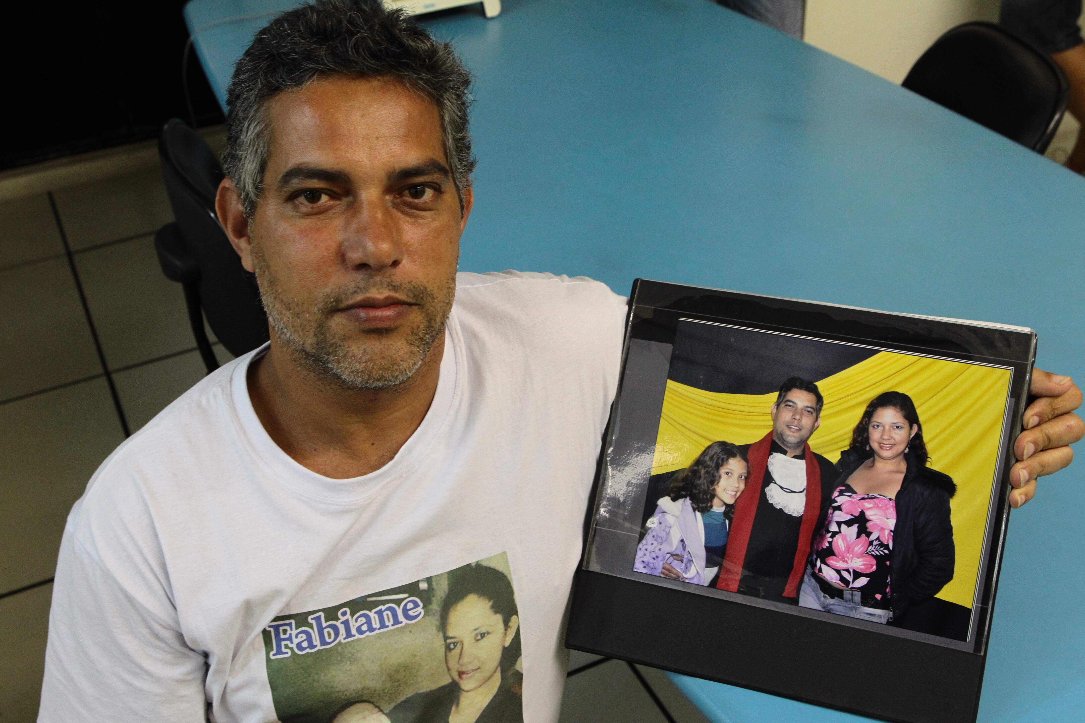 O viúvo, porteiro Jaílson Alves das Neves, mostra foto com a mulher, Fabiane