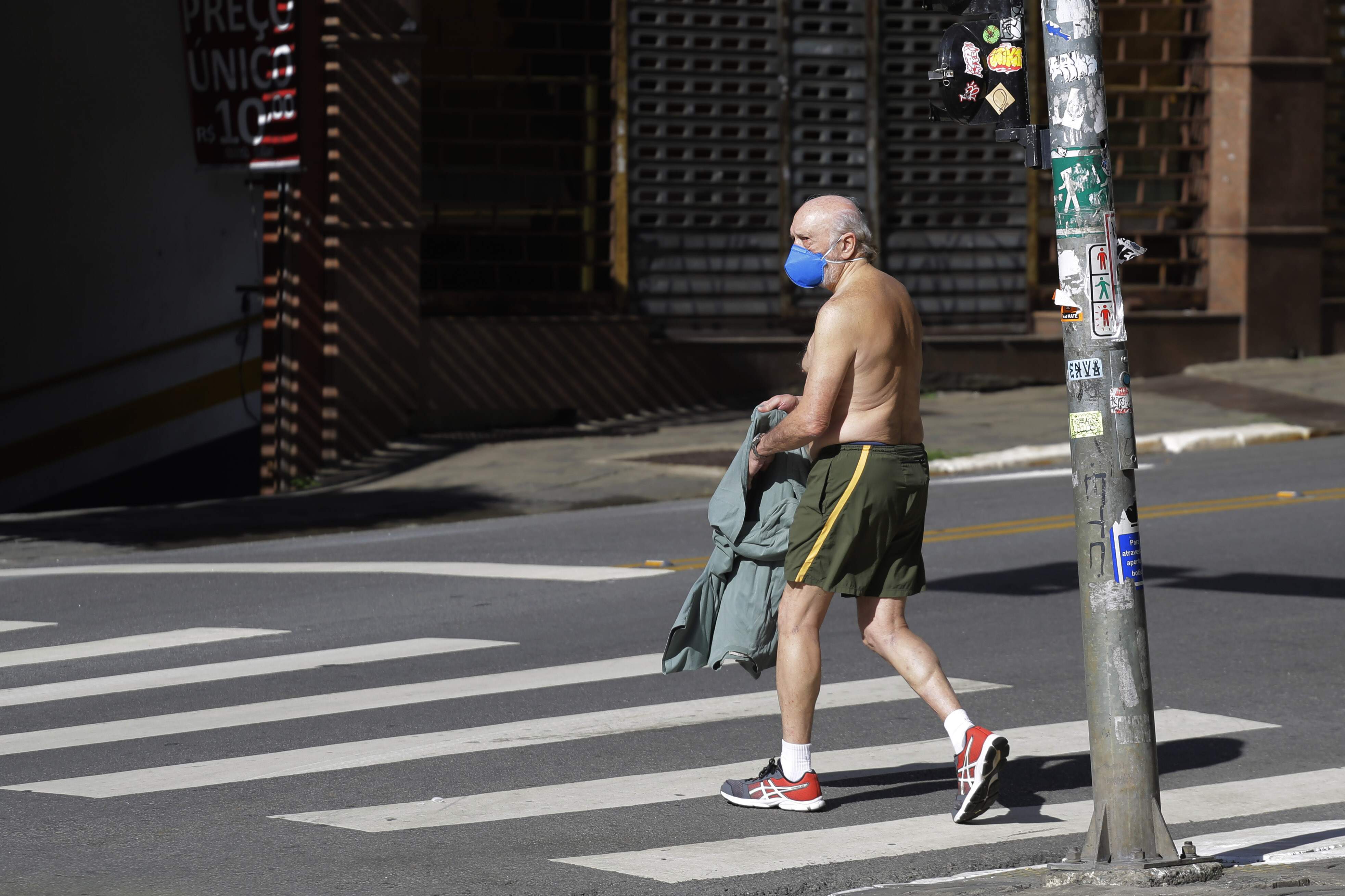 Idoso de máscara andando sem camisa pelas ruas de São Paulo