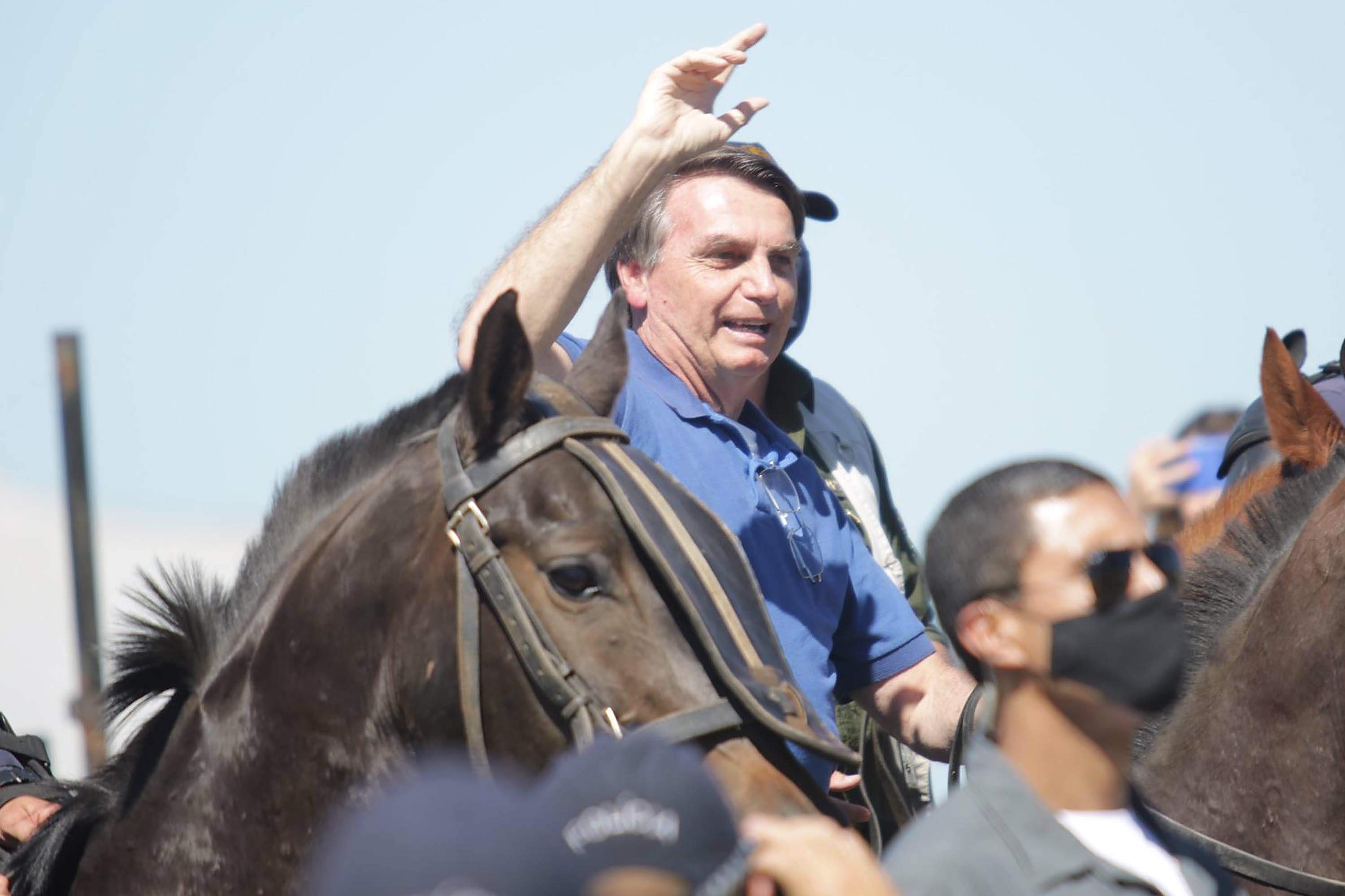 Sem máscara, Bolsonaro anda a cavalo durante manifestação pró-governo