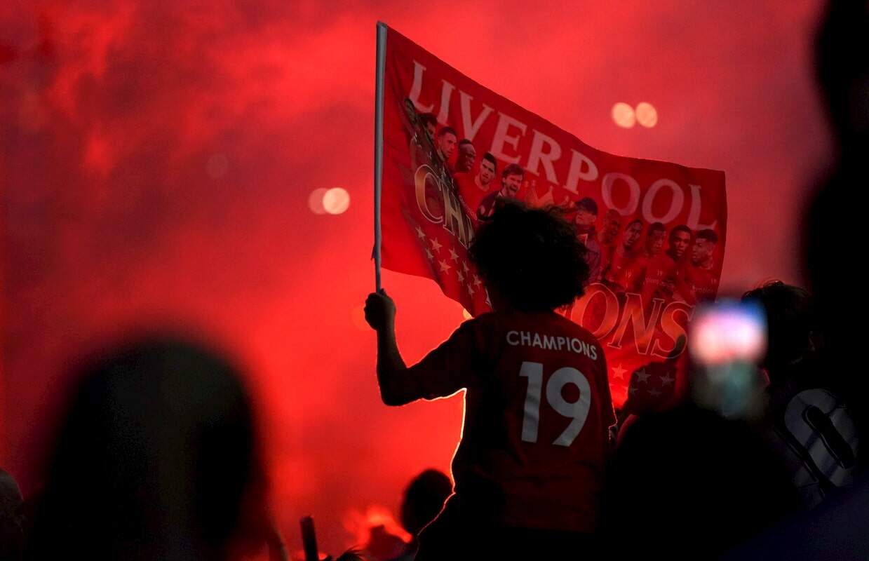 Torcedores comemoram do lado de fora do estádio Anfield Stadium, em Liverpool
