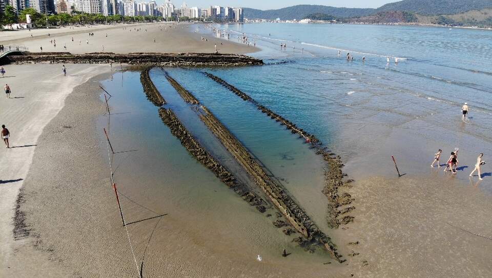 Maré baixa revela vestígios de uma embarcação encalhada na orla de Santos