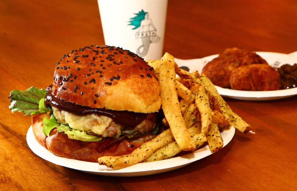 Tuna Burger, tem blend de partes de atum, muçarela artesanal, maionese especial, ketchup de goiaba, no brioche. A batata é temperada com a alga nori 