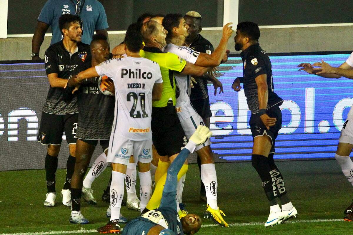 Pitana, de amarelo, no meio da briga entre jogadores do Santos e da LDU
