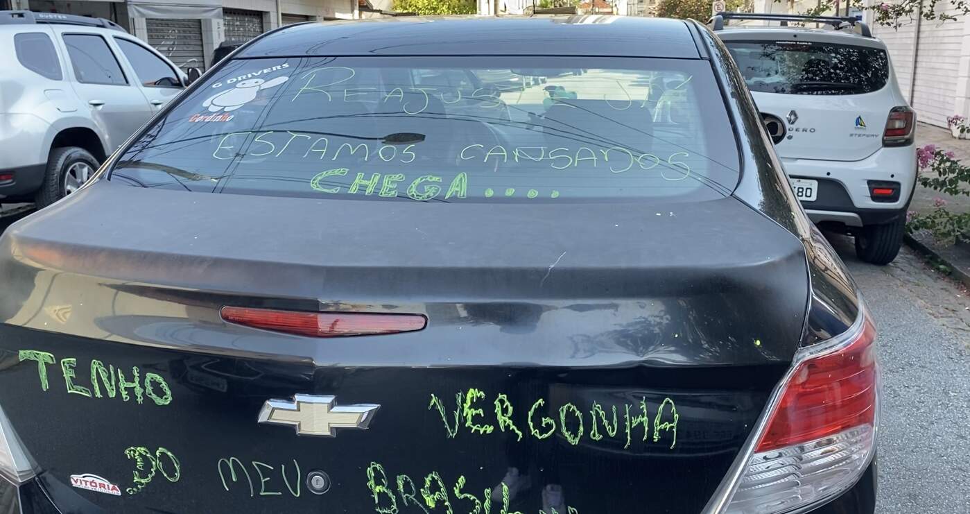 Motorista pinta o carro com palavras de protesto durante manifestação 